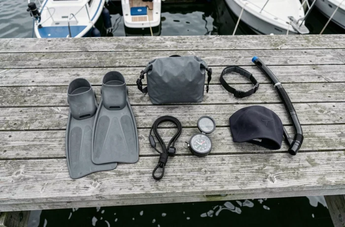 Plat posé d'équipements nautiques et sportifs sur un ponton en bois usé avec marina floue en arrière-plan